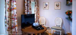 Télévision sur une petite table dans l'appartement Sagan dédié à un week-end en amoureux en Normandie.